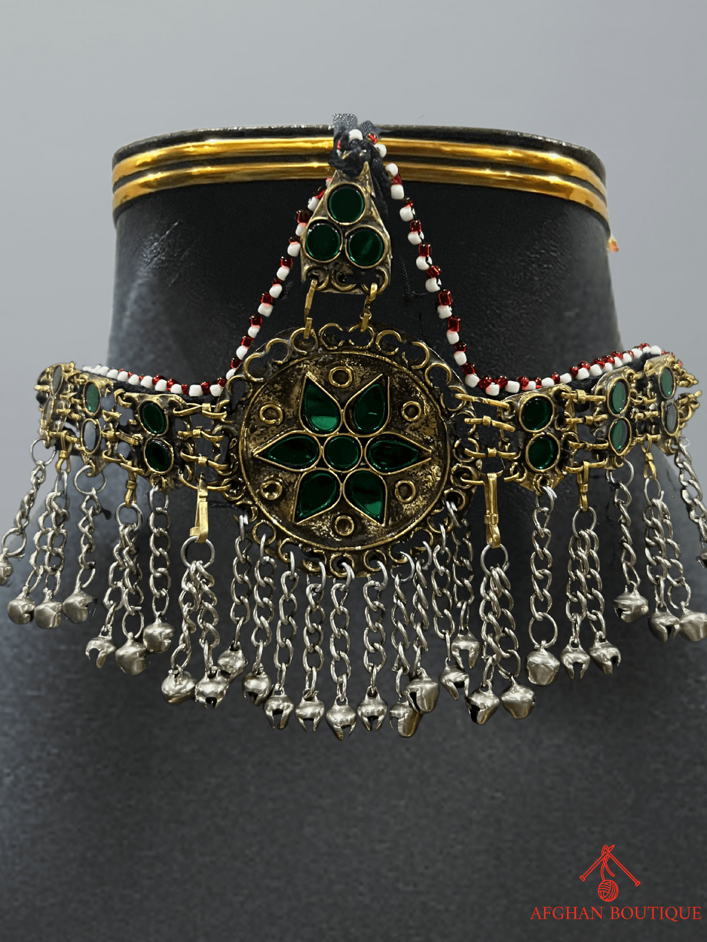 Close-up view of emerald green handcrafted Afghani headpiece showing fine metalwork and traditional ethnic jewelry details.
